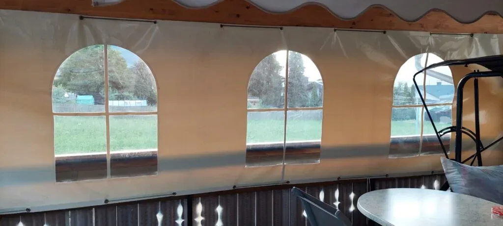 Transparente Schutzplanen mit Fensteröffnungen für Terrassenüberdachung.